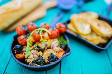 Baked escargot in butter with herbs and tomatoes
