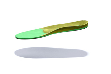 Obraz premium Plantare ortopedico verde e giallo su fondo bianco