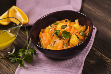 Salad with fresh carrot, orange slices, pumpkin and  sunflower seeds. Selective focus