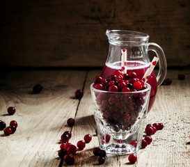 Cheerful funny juice from cranberries, berries with straws in a