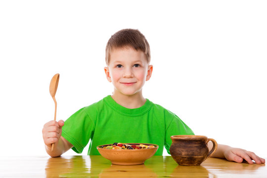 Smiling Boy Eating Oatmeal At The Table