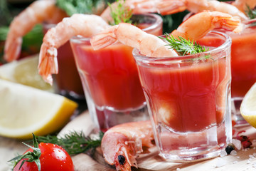 Shrimp cocktail in small glasses, cherry tomatoes, dill, parsley