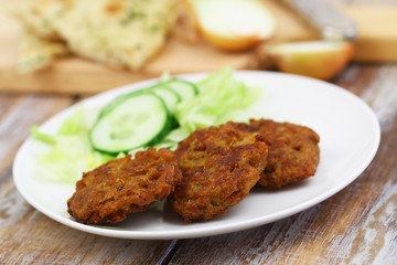 Onion bhajis with side salad on white plate, closeup
