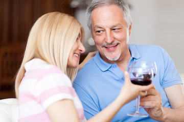 Mature couple toasting wine glasses