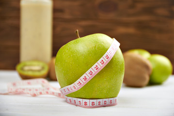 Green apple and measuring tape. Diet concept