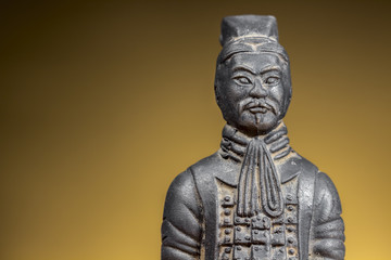 Fototapeta na wymiar Terracotta figurine of ancient chinese warrior on rising sun background. Clear space at left.