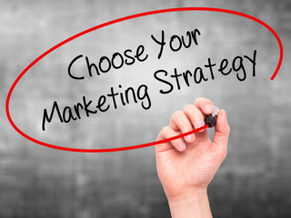 Man Hand writing Choose Your Marketing Strategy with black marke