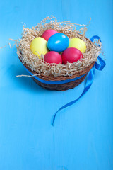 Easter eggs in a nest on blue background