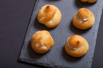 Set of small profiteroles on a black slate plate