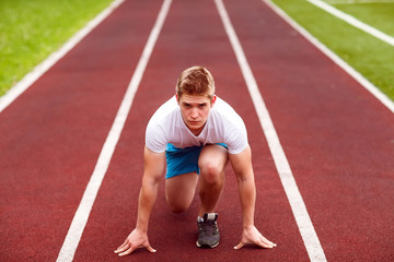 Beautiful athlete on a race track is ready to run