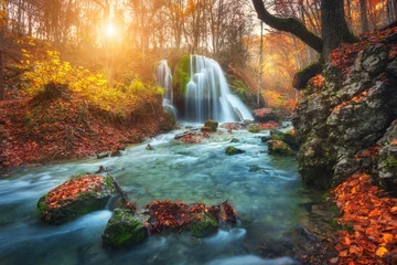 Foto auf Alu-Dibond Beautiful waterfall at mountain river in colorful autumn forest with red and orange leaves at sunset. Nature landscape © den-belitsky