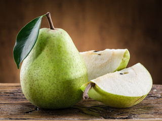 Pear fruit with leaf on wooden background.