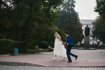 groom holds bride in his arms and twisted