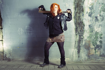 Fototapeta na wymiar Smiling punk woman posing with a baseball bat.