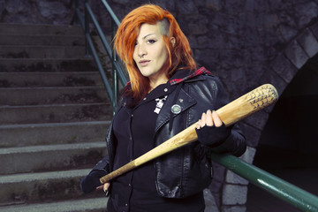 Aggressive punk woman posing with a baseball bat.