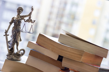 Justice statue with sword and scale and books. Law concept