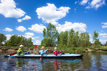 Fototapeta na wymiar Young people are kayaking on a river in beautiful nature. Summer sunny day