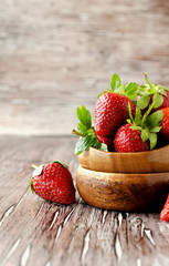 Fresh strawberries in a wooden bowl, selective focus