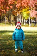 Little girl playing in autumn park