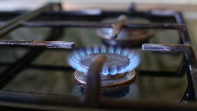 Gas Stove Burner Lighting Close Up Center. a close up shot of a gas burner on a stove being lit. audio included