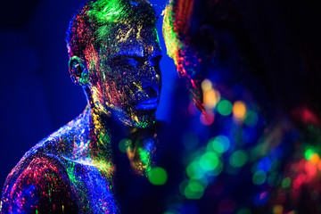 people are colored fluorescent powder. a pair of lovers dancing