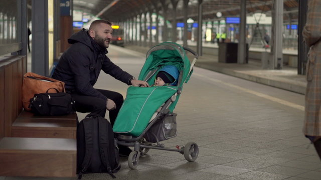 Parents sitting near the station and plays with baby 
