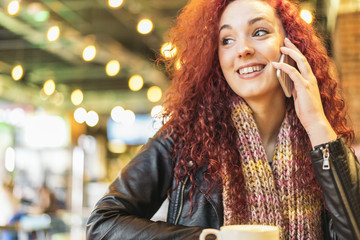 Young woman talking on the phone in coffee shop. © santypan