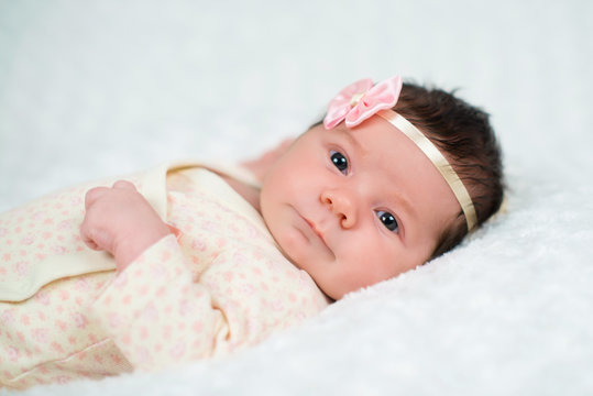 Cute newborn baby girl with pink bow