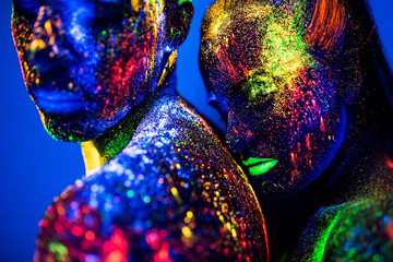 people are colored fluorescent powder. a pair of lovers dancing