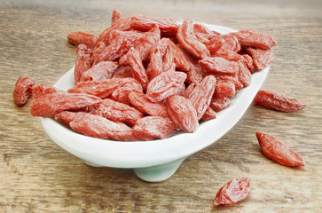 auf einem Holztisch Schale mit getrockneten Goji Beeren