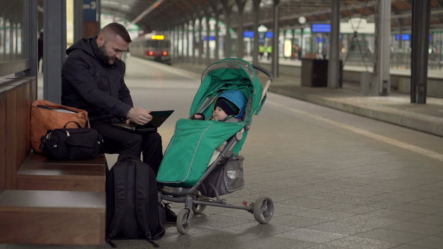 Father with son using mobile on station 
