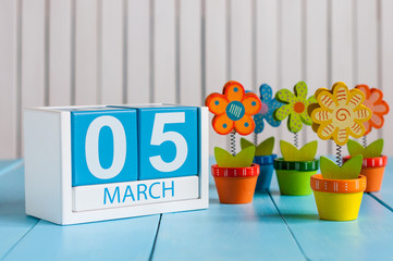 March 5th. Image of march 5 wooden color calendar with flower on white background.  First spring day, empty space for text