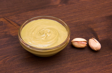 Pistachio cream on bowl on wooden table