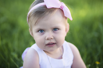 Closeup portrait of baby girl on green grass background