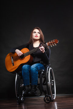 Woman invalid girl on wheelchair with guitar