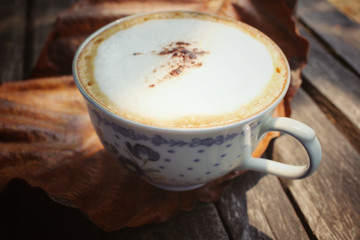 Cappuccino coffee with dried leaves