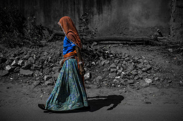 Indian woman in traditional clothing walking down the street.
