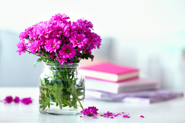 Beautiful flowers in vase on table in room