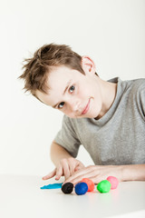 Child flattening clay on table