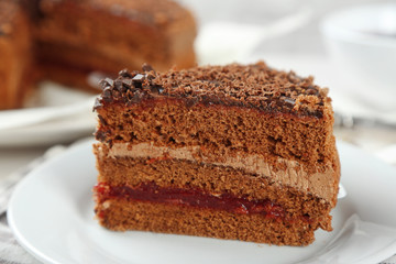 Sliced chocolate cake on plate, on wooden table  background