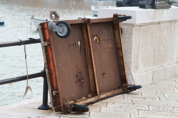 Carretto a mano attaccato alla ringhiera del lungomare