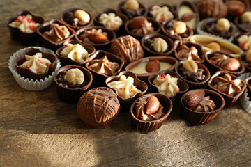 Delicious chocolate candies on wooden background, close up