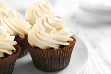 White cupcakes on wooden table