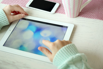 Woman using digital tablet on table close-up