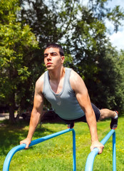 athlete doing pull-up on horizontal bar.Mans fitness outdoor