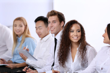 Fototapeta premium Young businesswoman with curly hair talking to colleague at the office meeting