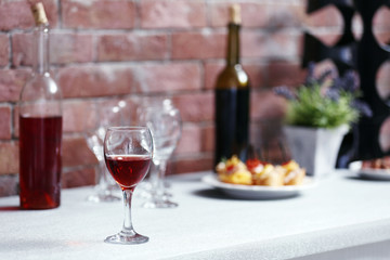 Wine bottles and canape on the kitchen table against a brick wall