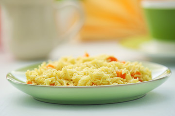 Stewed rice with a carrot on a plate