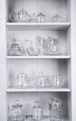 Fototapeta na wymiar Glass dishes on shelves in the kitchen