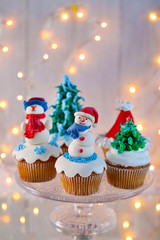 Christmas cupcakes with lights on background